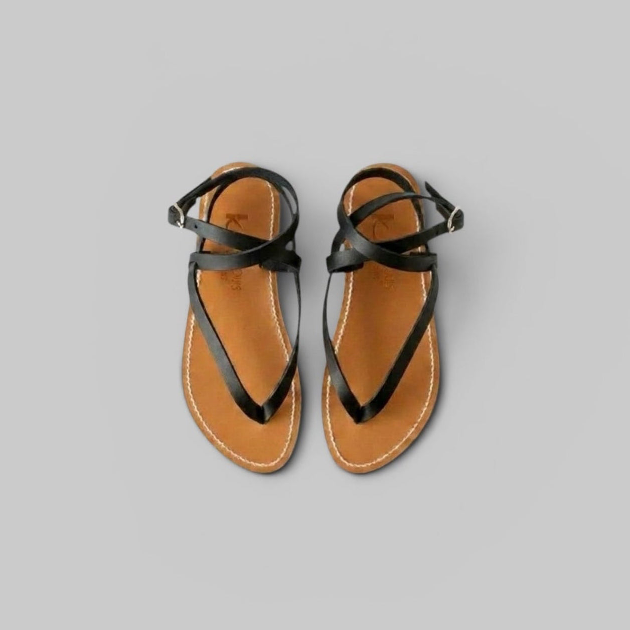 Pair of black strappy sandals on a gray background - her. 
